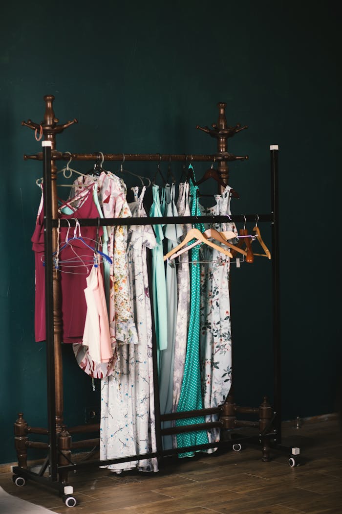 services-bg A stylish collection of dresses on a wooden clothes rack against a dark wall, creating a chic aesthetic.