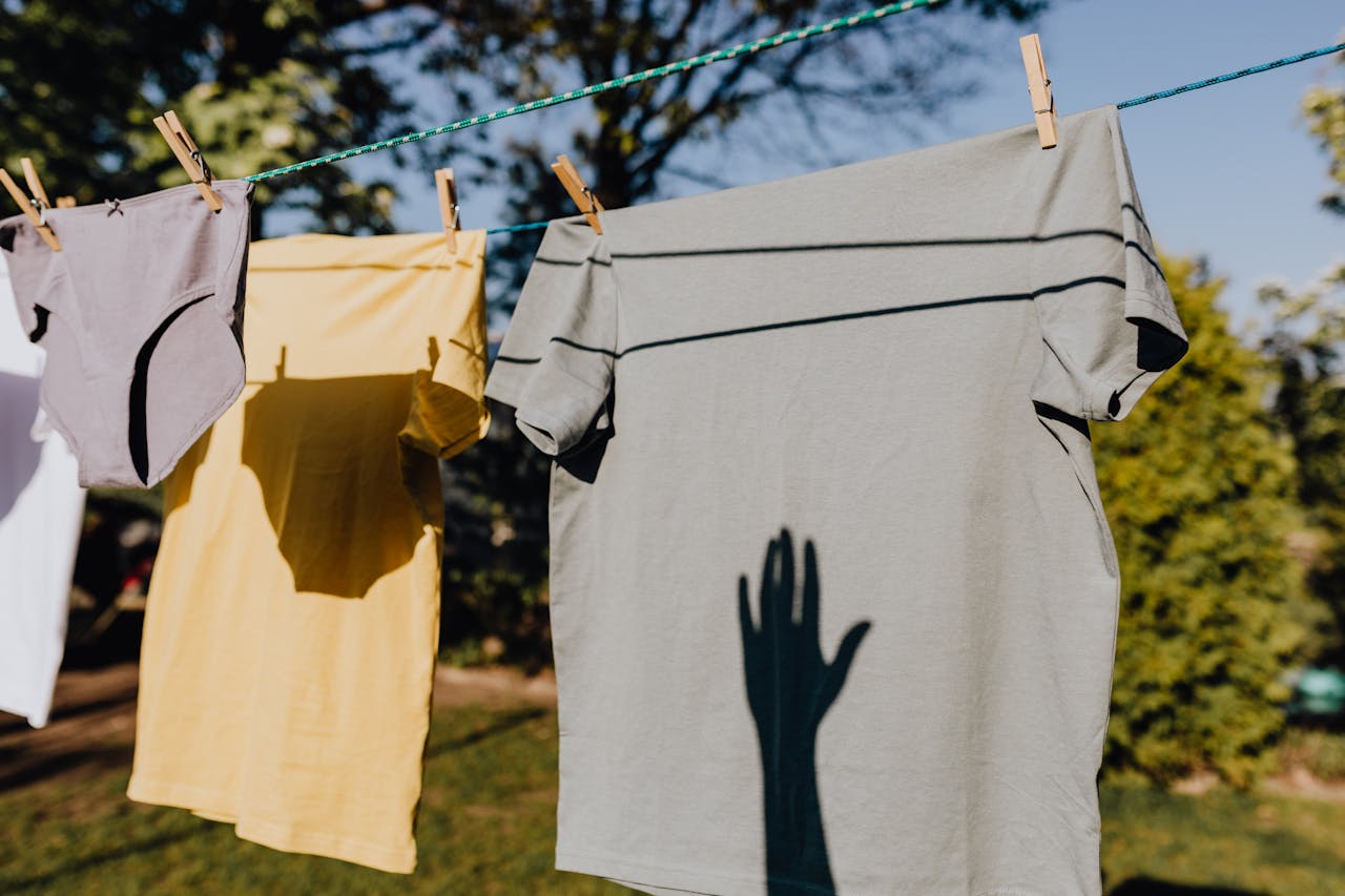 home-hero Shadows cast on clothing hanging outside on a sunny day, evoking a sense of fresh and serene rural life.